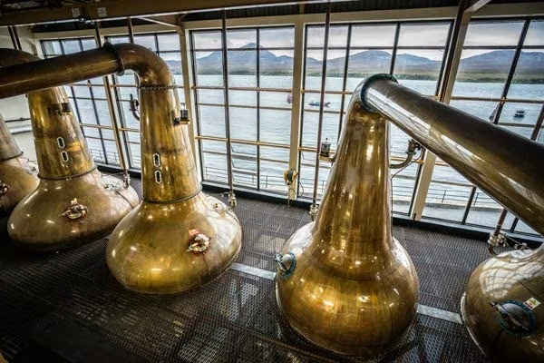 Kupferbrennblasen der Caol Ila Distillery mit Blick auf den Sound of Islay